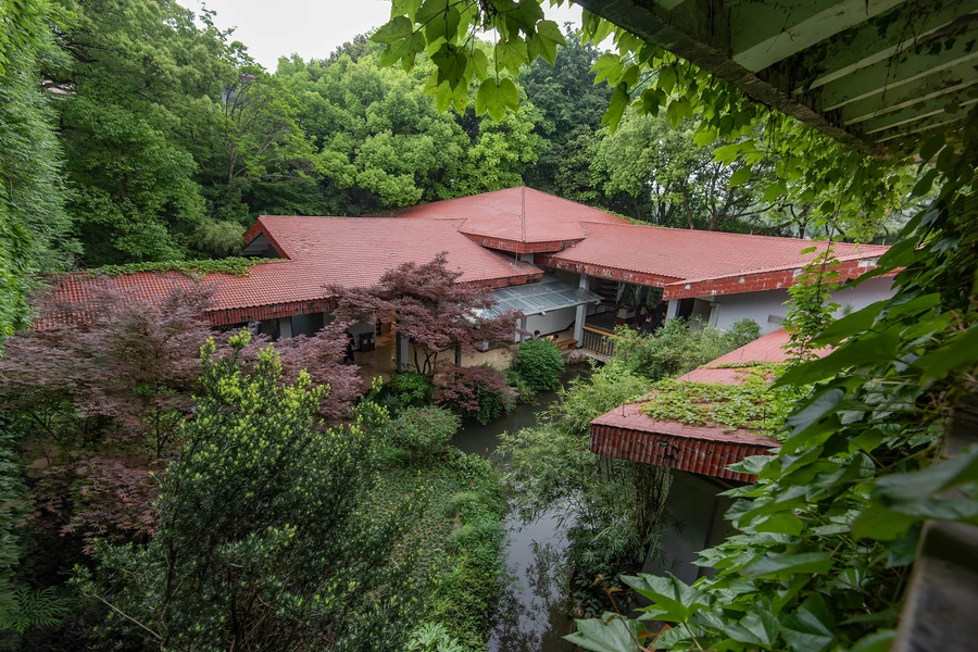 The red-roofed Shuangfeng campus of the China National Tea Museum surrounded by dense green gardens in Hangzhou.