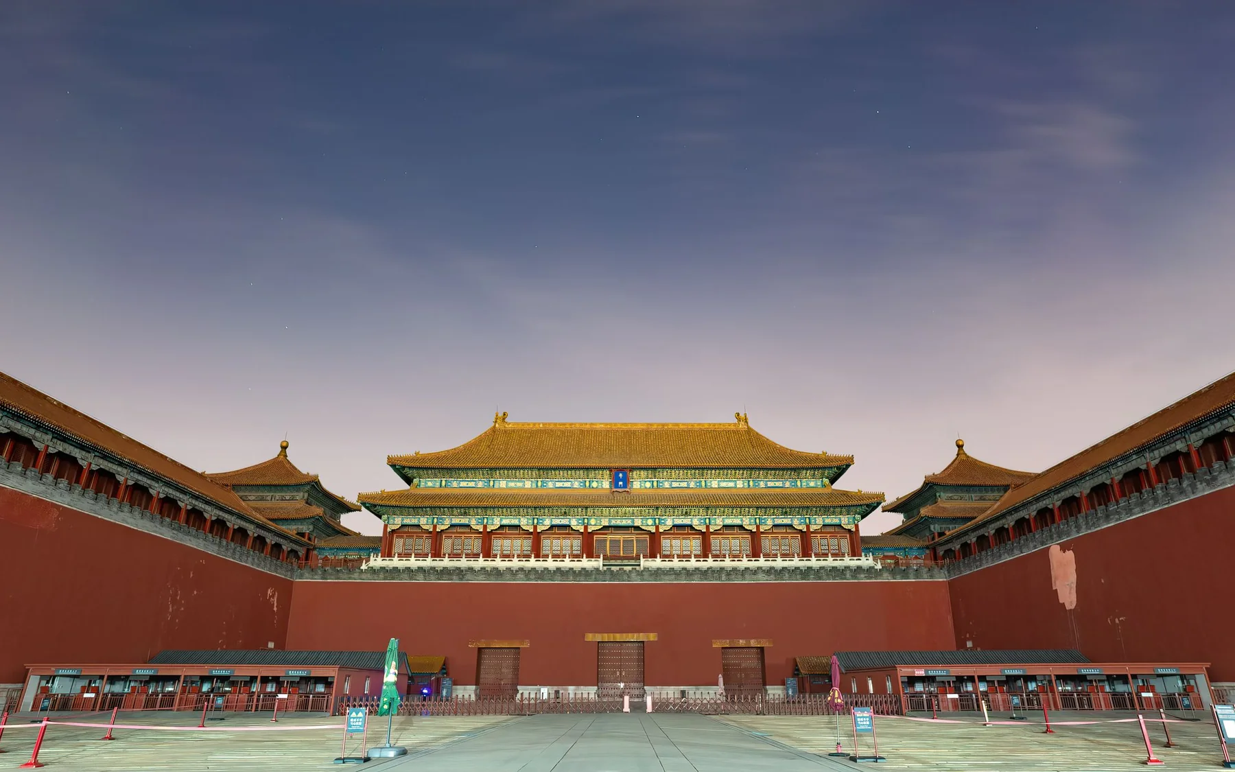 The Meridian Gate and its red courtyard walls under a twilight sky at the Forbidden City in Beijing