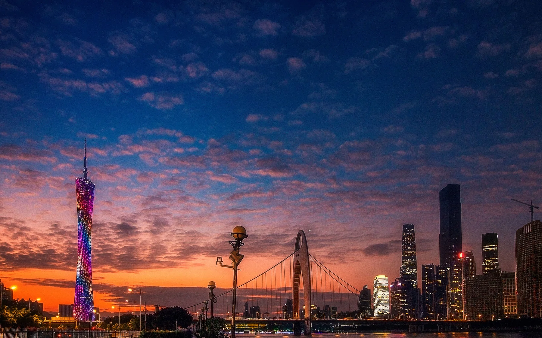 A photographer-composed sunset panorama of Guangzhou with the full Canton Tower, Liede Bridge, Pearl River reflections and the Zhujiang New Town skyline.