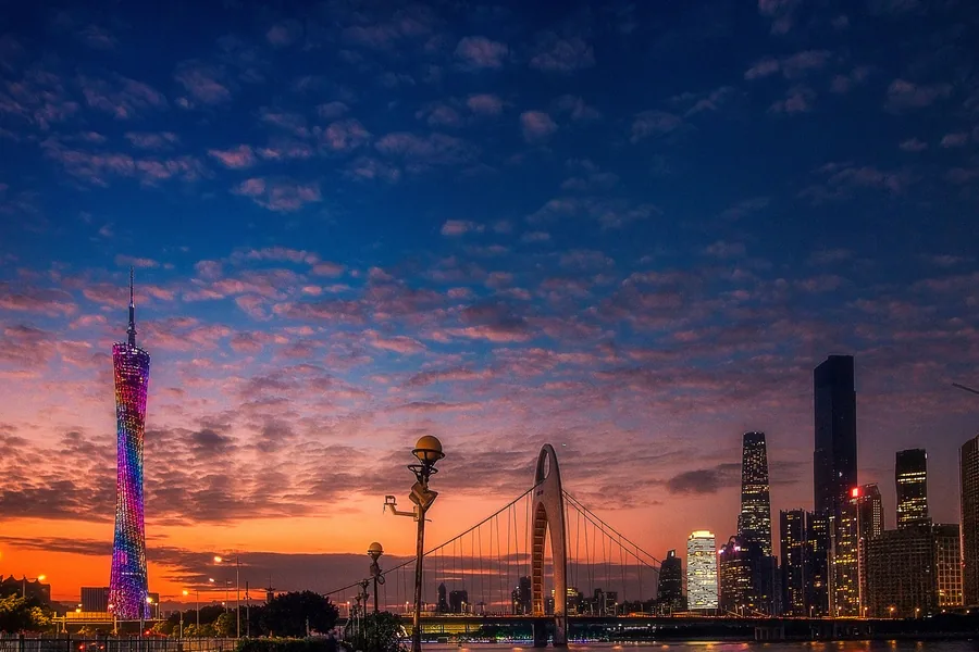 A photographer-composed sunset panorama of Guangzhou with the full Canton Tower, Liede Bridge, Pearl River reflections and the Zhujiang New Town skyline.