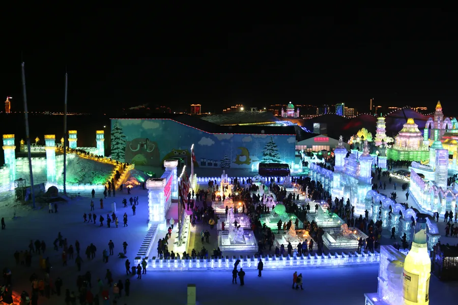 Illuminated ice palaces and towers at Harbin Ice and Snow World after dark