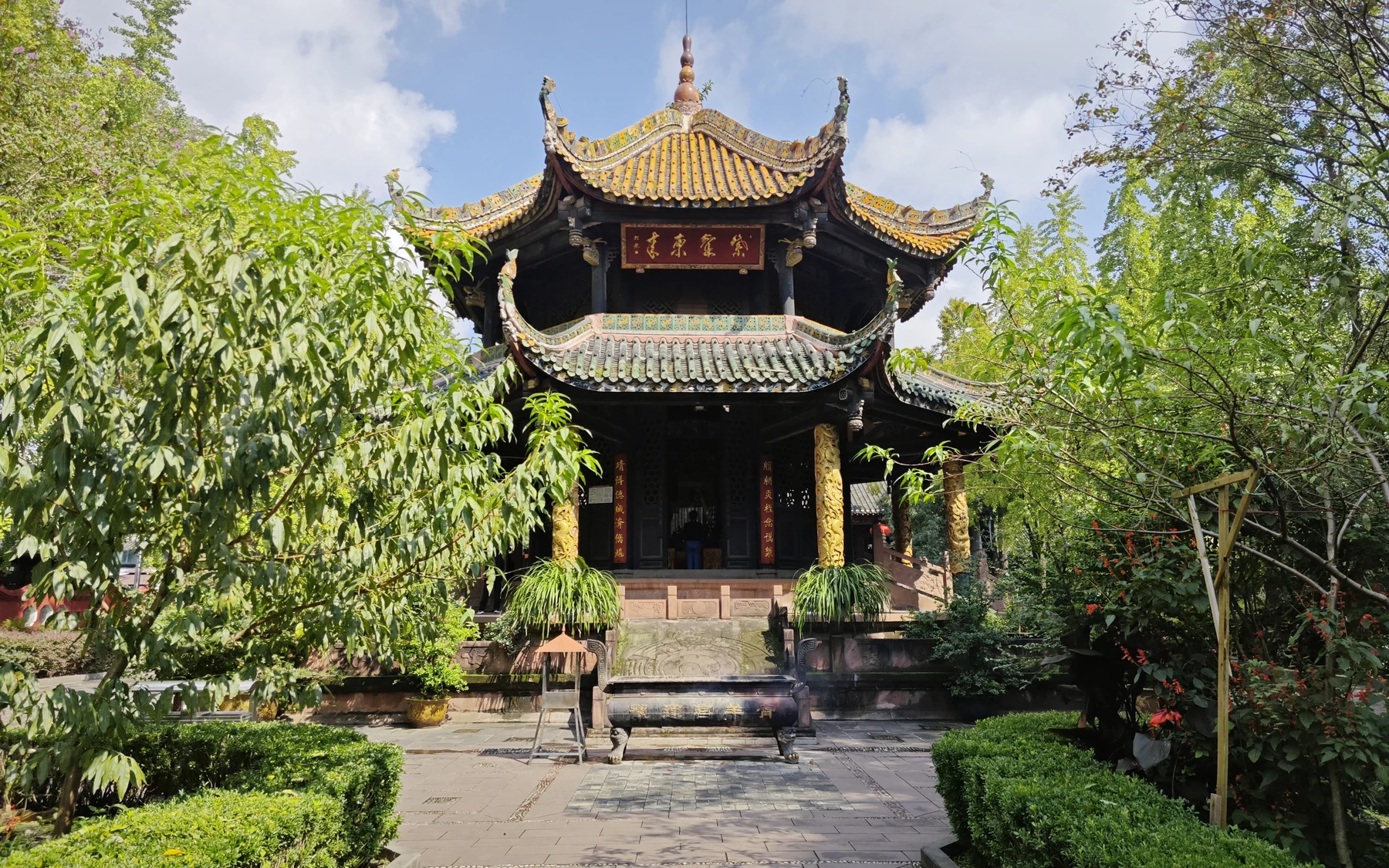 The complete Eight Trigrams Pavilion at Qingyang Palace, centred beneath a clear blue sky and framed by foliage.