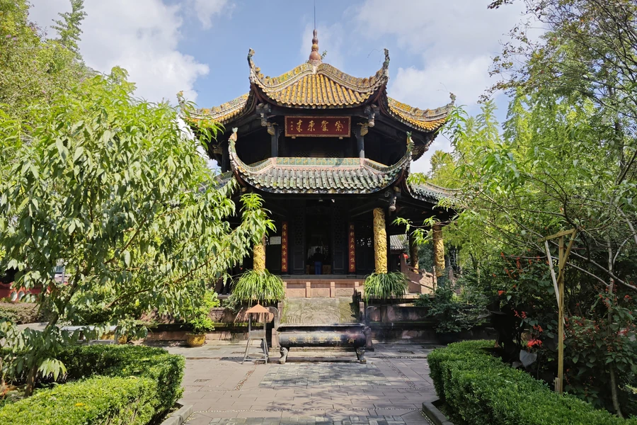 The complete Eight Trigrams Pavilion at Qingyang Palace, centred beneath a clear blue sky and framed by foliage.