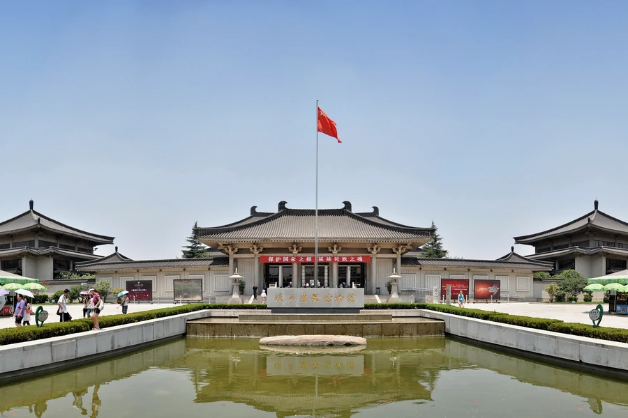The complete Tang-revival front elevation of Shaanxi History Museum in Xi'an, centred behind its flagpole and reflecting pool