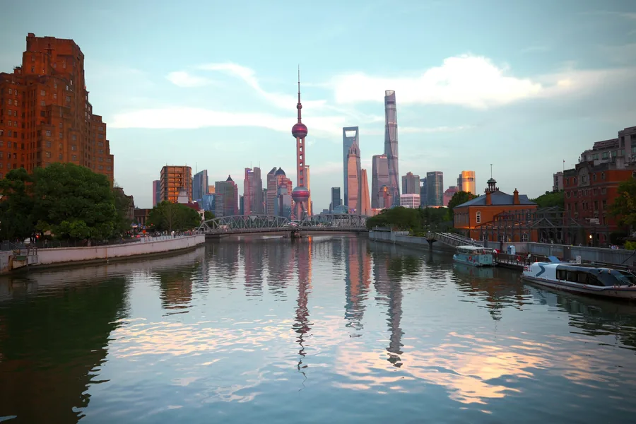 The Lujiazui skyline reflected in water beyond historic waterfront buildings near the Bund in Shanghai