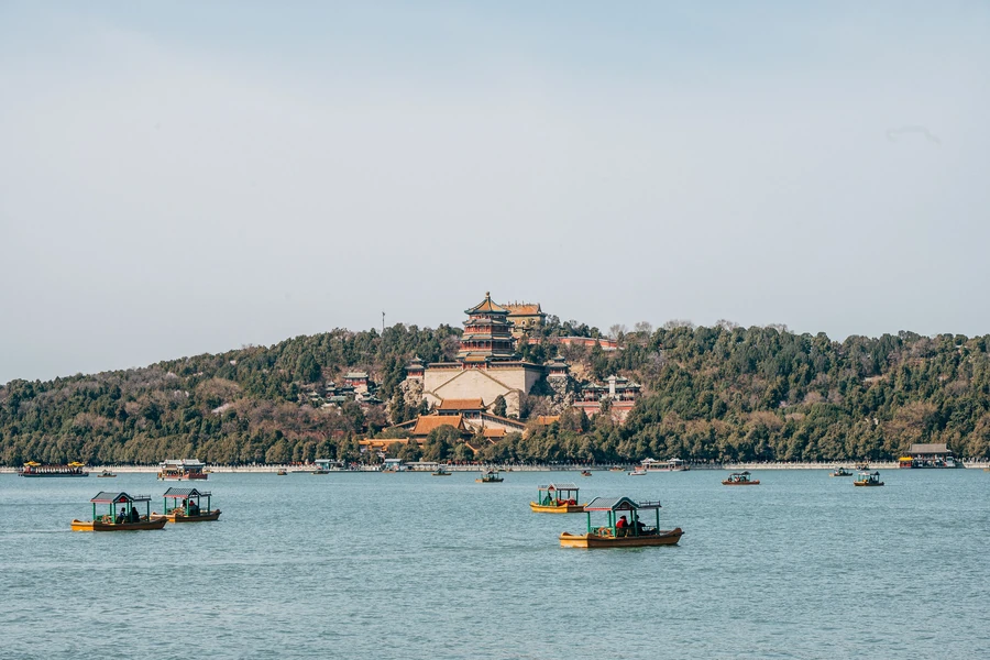 The Tower of Buddhist Incense and Longevity Hill rising beyond boats on Kunming Lake at Beijing's Summer Palace