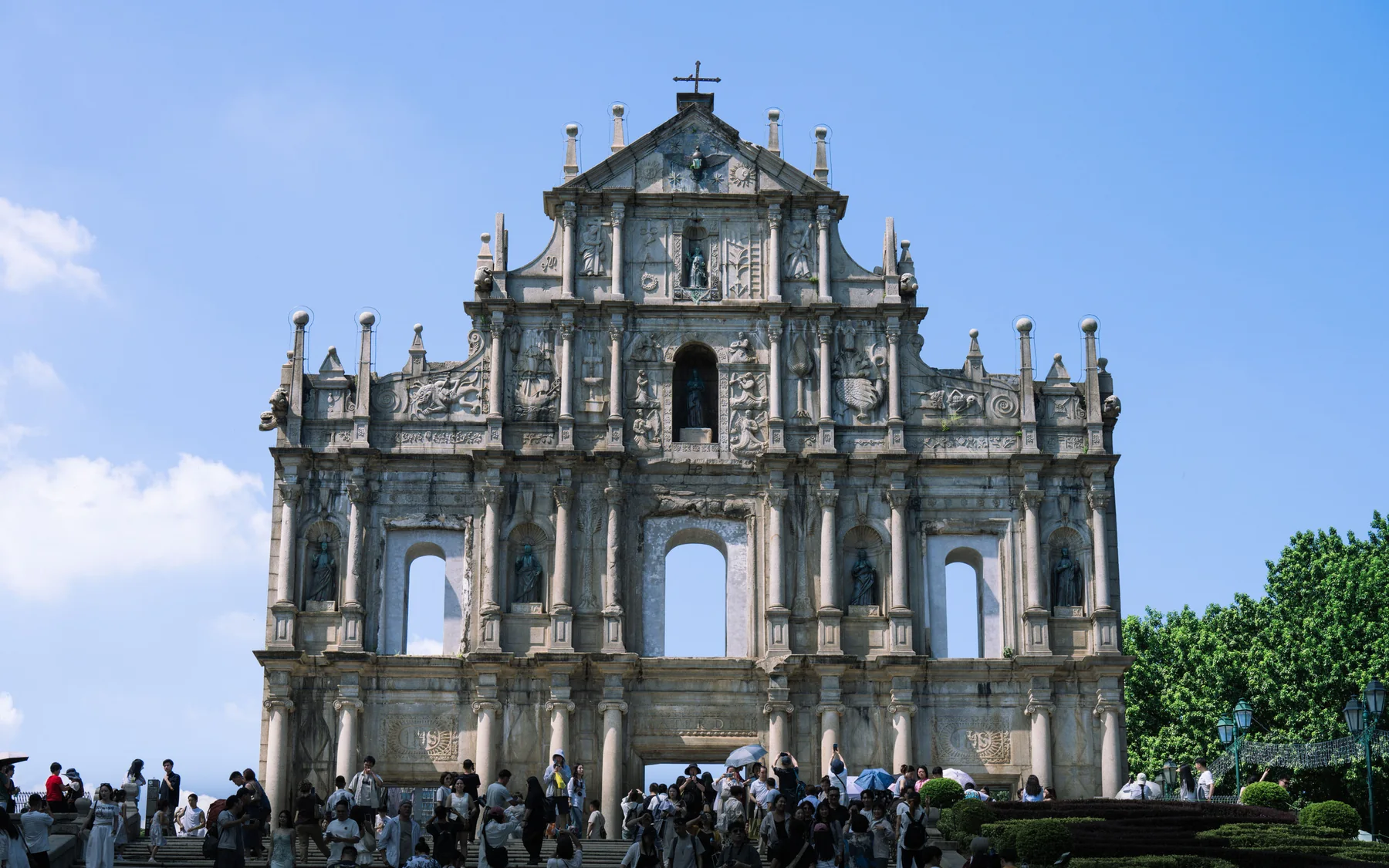 The Ruins of Saint Paul's facade rising above its broad stone steps under a clear blue sky