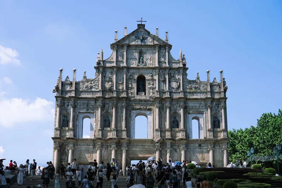 The Ruins of Saint Paul's facade rising above its broad stone steps under a clear blue sky