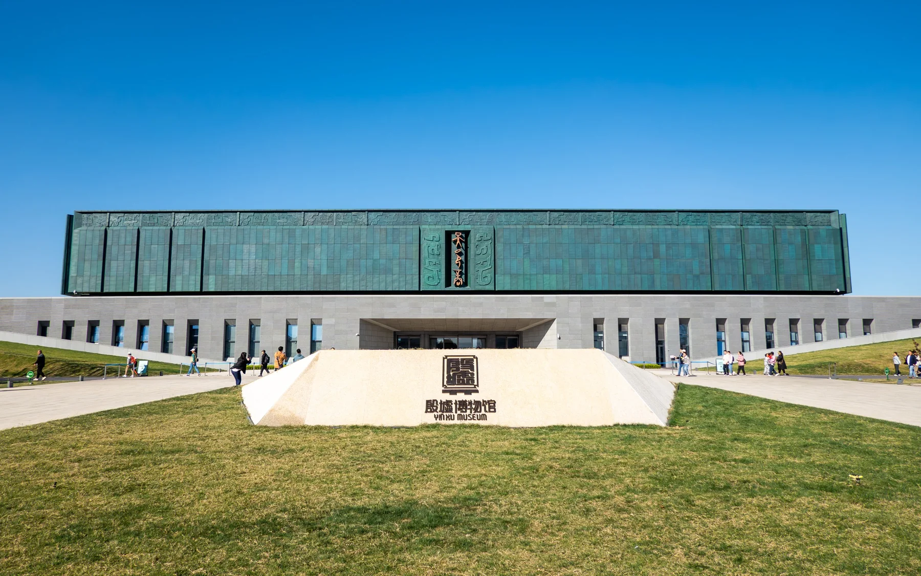 Front elevation of the new Yinxu Museum in Anyang, with its long green facade, central approach and reflecting pools forming a symmetrical composition.